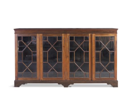 A MAHOGANY LONG RECTANGULAR LOW BOOKCASE, with moulded top above astragal glazed panel doors, on bracket feet. 182cm wide  x 