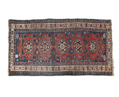 A FINE SHIRVAN CARPET, 1903, with signature panel, the large rectangular field woven with five central geometric red lozenges