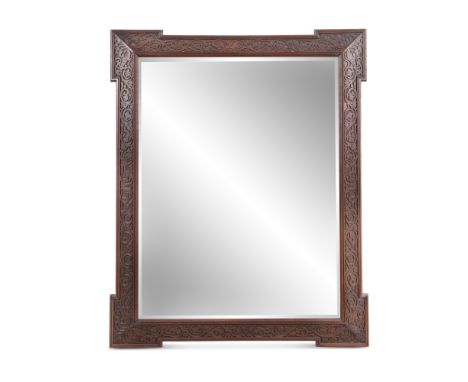A PAIR OF ARTS AND CRAFTS CARVED WOOD MIRRORS, each fitted with bevelled glass plates, with foliate carved borders and outset