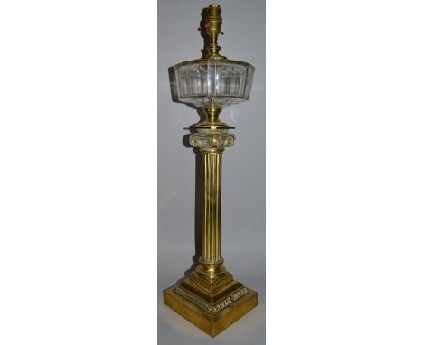 A BRASS CORINTHIAN COLUMN LAMP with glass reservoir 27ins high.
