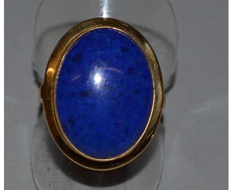 AN 18CT YELLOW GOLD AND LAPIS SET OVAL DRESS RING.