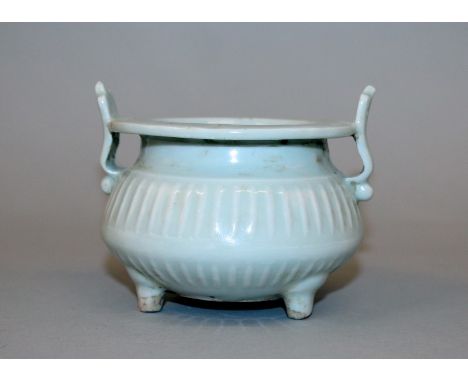 A CHINESE CELADON PORCELAIN TRIPOD CENSER, with double upright handles, 3.5in high to top of handles & 3.8in diameter at rim.