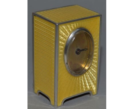 A GOOD ENGINE TURNED SILVER .935 AND YELLOW ENAMEL MINIATURE CLOCK with oval dial on bracket feet 1.75ins high.