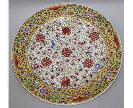 A CHINESE FAMILLE ROSE PORCELAIN PLATE, decorated to its centre with bats and Shou symbols reserved on a ground of scroll-ste