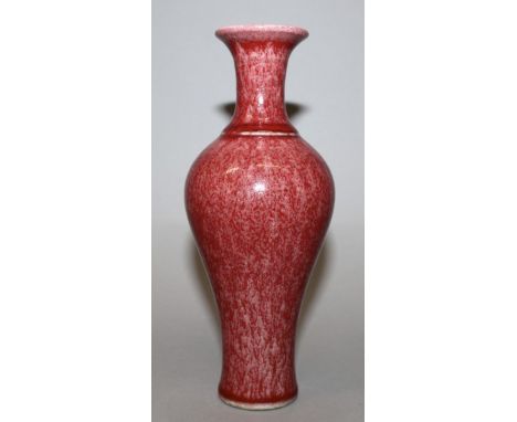 A CHINESE PEACH BLOOM PORCELAIN VASE, the sides of the baluster form body applied with a mottled glaze, the base with an unde