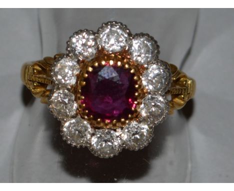 A GOOD RUBY AND DIAMOND CLUSTER RING with pierced shoulders in 9ct yellow gold. Provenance: CARRINGTON & CO LTD.