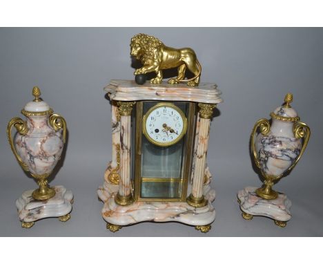A GOOD FRENCH GREY VEINED MARBLE THREE PIECE CLOCK SET, the clock with lion finial and column supports, the movement by F. FO