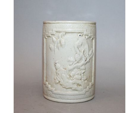 A CHINESE CREAM GLAZED PORCELAIN BRUSHPOT, the sides moulded in relief with panels of birds, rockwork and foliage, the base w