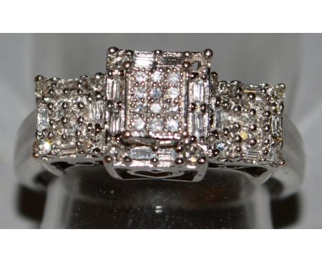 A 9CT WHITE GOLD SQUARE SHAPED DIAMOND RING.