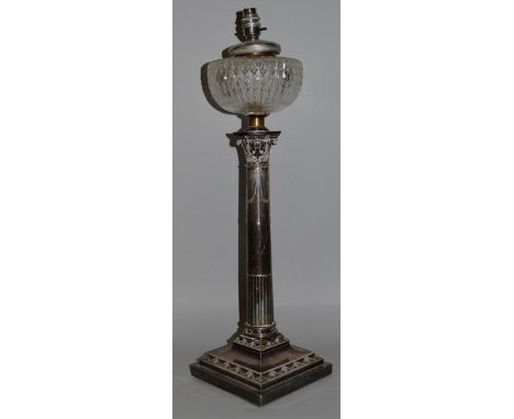 A GOOD CLASSICAL CORINTHIAN COLUMN OIL LAMP with glass reservoir, on a square stepped base 25ins high.