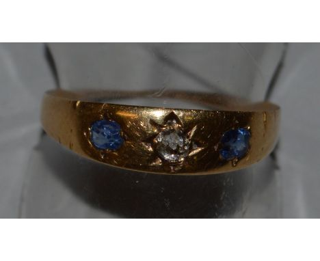 A DIAMOND AND SAPPHIRE THREE STONE RING set in 18ct yellow gold.