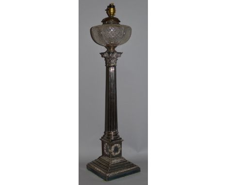A GOOD CLASSICAL CORINTHIAN COLUMN OIL LAMP with glass reservoir, on a square stepped base with bead edge 27ins high.