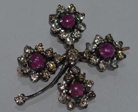A DIAMOND AND RUBY CLOVER BROOCH.