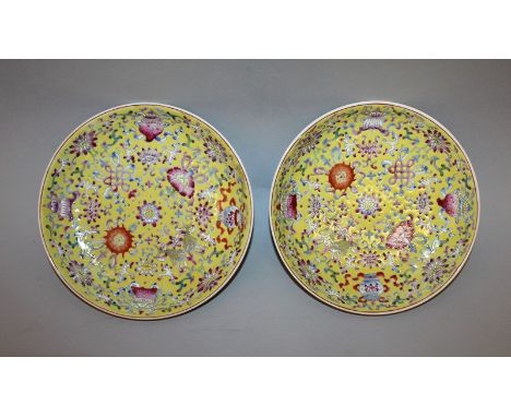 A PAIR OF CHINESE FAMILLE ROSE YELLOW GROUND PORCELAIN DISHES, each decorated with the Eight Buddhist Emblems, each base with