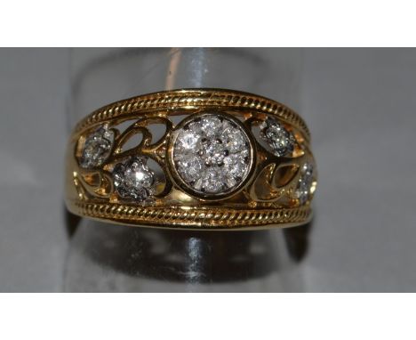AN 18CT YELLOW GOLD PIERCED AND DIAMOND SET RING.
