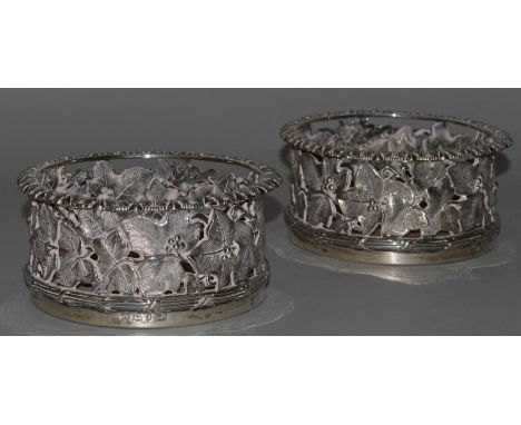 A PAIR OF VICTORIAN SILVER PIERCED WINE COASTERS, 5.5ins diameter, decorated with fruiting ivy. Sheffield 1838 Maker: Henry W