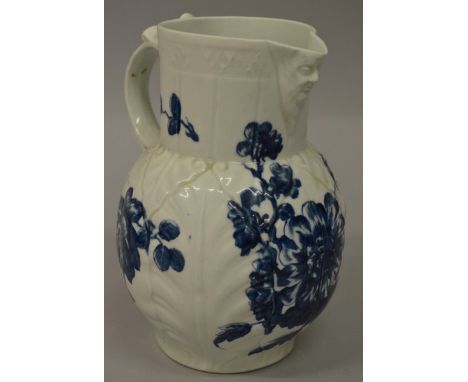 AN 18TH CENTURY WORCESTER MASK JUG painted in under-glaze blue with “Heavy Naturalistic Sprays” workman's mark (spout reduced