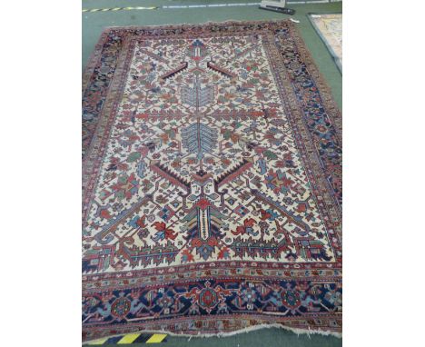 Persian rug with cream central background and geometric patter of light blue, greens &amp; reds &amp; multi geometric border 