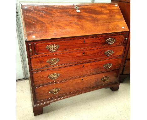 A George III mahogany fall front bureau with fitted interior, 4 graduating drawers with brass drop handles, on ogee bracket f