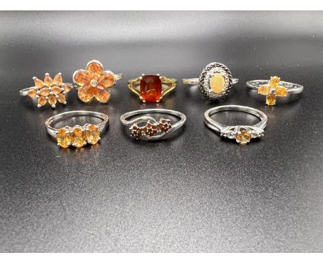 8 silver rings stamped '925' with orange coloured stones in a variety of settings gross weight 