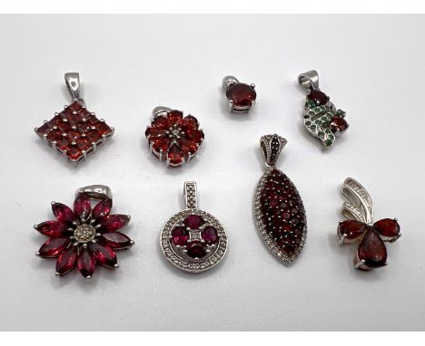 8 silver pendants set with a variety of red coloured stones 