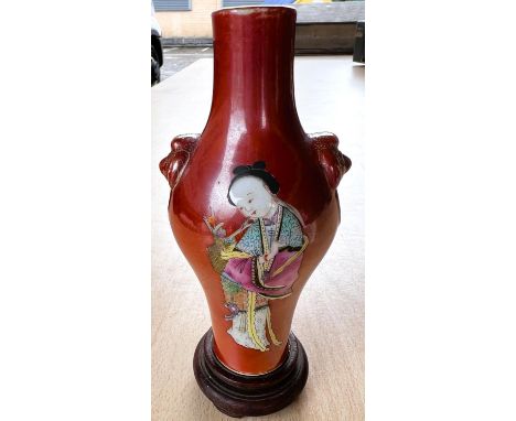 A small Chinese vase with red ground colouring, two detailed images of ladies in traditional dress, gilt relief masks to each