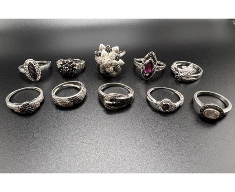 10 silver rings all set with black pave set stone chips, testing as black diamonds, some with similar clear stones, in a vari