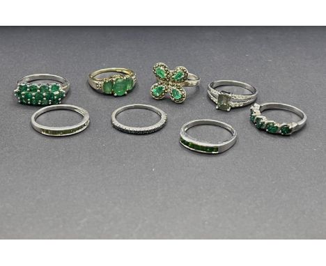 5 silver rings stamped '925' with emerald coloured stones in a variety of settings; 2 further silver rings set greens tones t