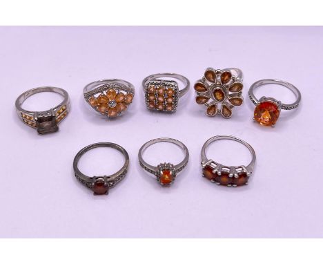 8 silver rings stamped '925' with orange coloured stones in a variety of settings gross weight 