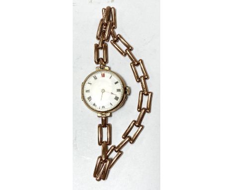 An early 20th century 9ct gold wrist watch with white enamel dial with Roman Numerals XII in red, gate link chain gross weigh