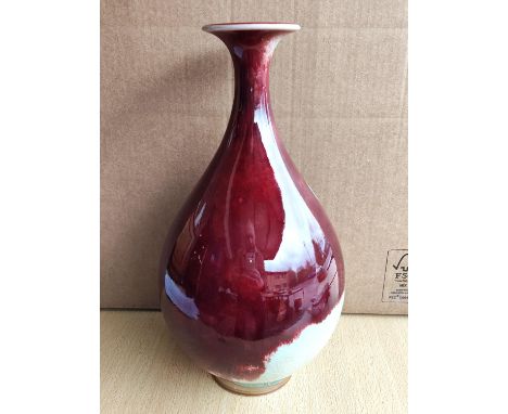 A modern Chinese "Sang de Boeuf" baluster vase with elongated neck and flared rim, square seal mark to base, ht.34cm (glaze c