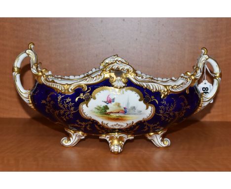 AN EARLY 20TH CENTURY COALPORT BOAT SHAPED TWIN HANDLED VASE, the blue and gilt ground hand painted with vignettes of exotic 