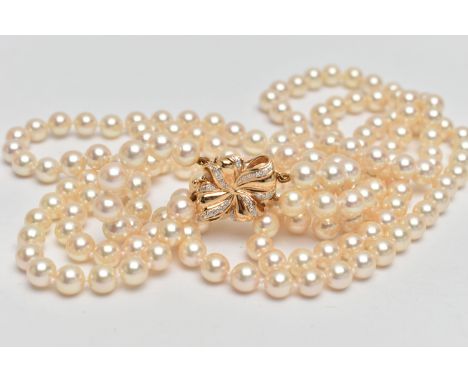 A CULTURED PEARL NECKLACE, designed with three strands of individually knotted cream pearls with a pink hue, each pearl measu