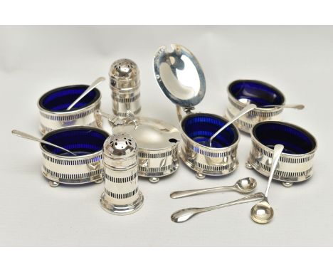 AN EIGHT PIECE SILVER CONDIMENT SET, comprising of four pierced salts each on four ball feet with blue glass inserts, two mat