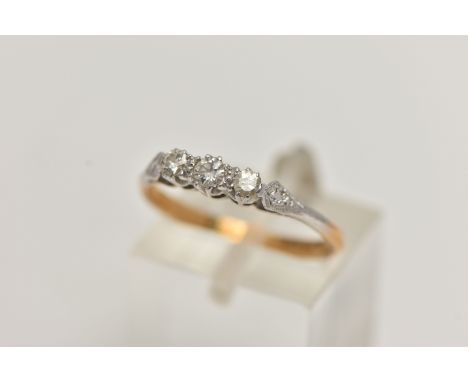 A THREE STONE DIAMOND RING, three round brilliant cut diamonds, prong set in white metal leading on to milgrain detailed shou