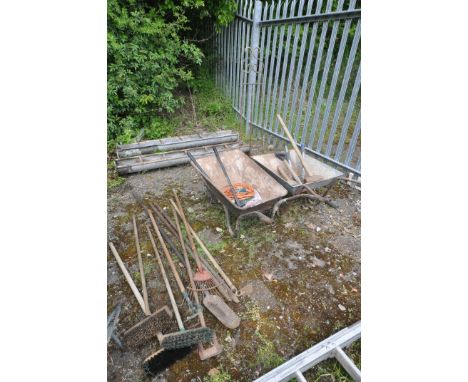 A SELECTION OF GARDEN TOOLS, to include two metal wheelbarrows, various hand tools including brushes rakes, etc (10+)