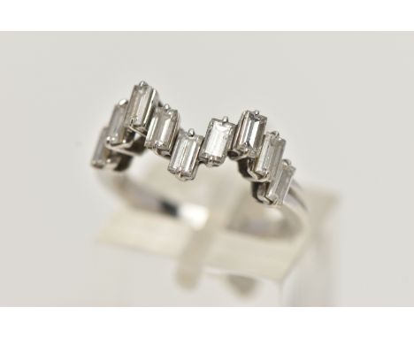 AN 18CT WHITE GOLD DIAMOND RING, designed with a wavy row of nine baguette cut diamonds, each in a two claw setting, estimate