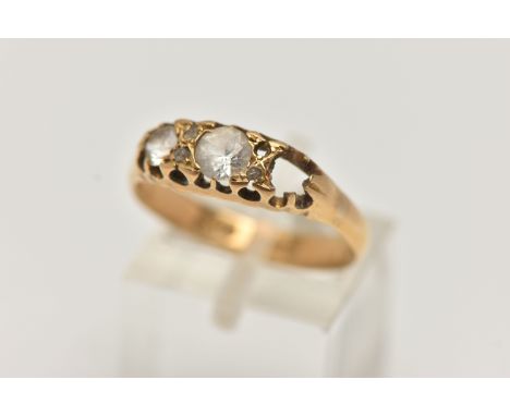 A YELLOW METAL GEM SET RING, mount designed for three stones and four accent stones, set with two colourless spinels and thre
