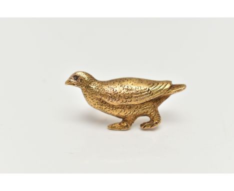 A YELLOW METAL BROOCH, in the form of a textured game bird, set with a small diamond chip eye, stamped 15c, fitted with a bro