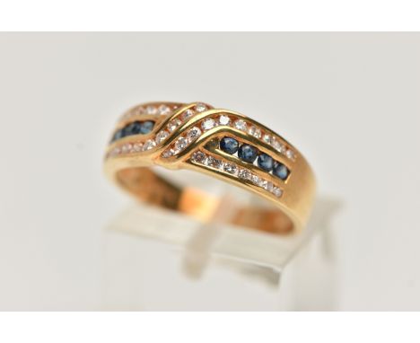 AN 18CT GOLD SAPPHIRE AND DIAMOND HALF ETERNITY RING, designed with a central row of small circular cut blue sapphires, betwe