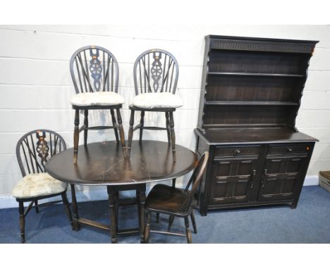A DARK OAK DINING SUITE, comprising an oval gate leg table, width 128cm x depth 87cm x height 75cm, four wheel back chair and