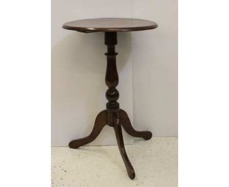 A early 19thC fruitwood and mahogany wine table, circular top with bevelled edge on a tripod base on turned baluster column, 