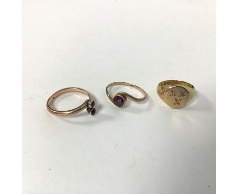 Three 9ct gold rings, including a signet style ring with three crosses (F), a crossover ring set two amethysts (K) and a sing