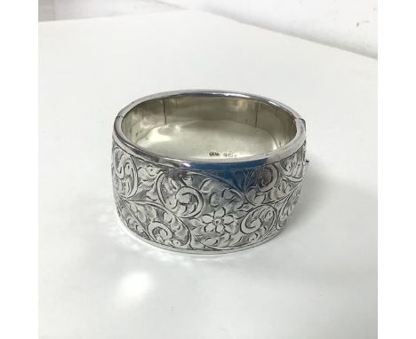 A 1930s/40s Birmingham silver bangle with clasp and foliate decoration to one side (3cm x 6cm) (47.12g)
