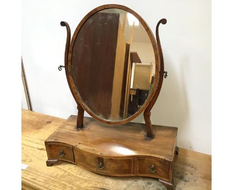 An Edwardian mahogany dressing table mirror, the oval glass on S scroll supports, on serpentine fronted base fitted three fri