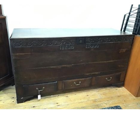 A large early 18thc oak mule chest, with likely later top and hinges above a moulded frieze of entwined vines and inscribed I