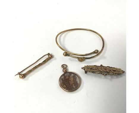 An assortment of Victorian and Edwardian 9ct gold jewellery including two bar brooches, one lacking pin, a bangle (d.6cm) and