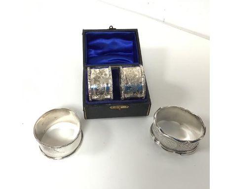 A pair of Edwardian silver napkin rings with foliate decoration in original box (each: 2.5cm x 4.5cm) and an oval shaped napk