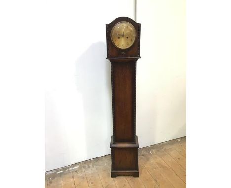 An oak 1920s grandmother clock with domed top above a metal dial with arabic numerals, with moulded edges, on bracket feet, i