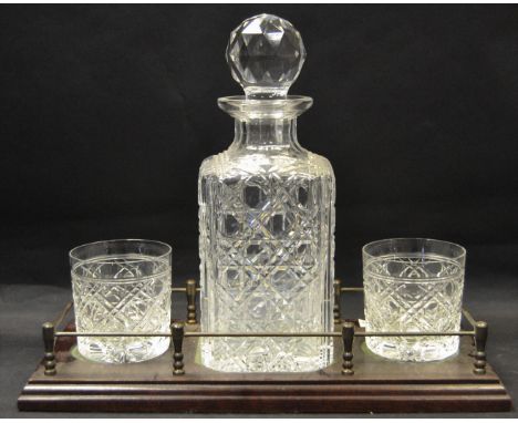 A whisky companion set comprising a decanter and two tumblers on a brass galleried stand